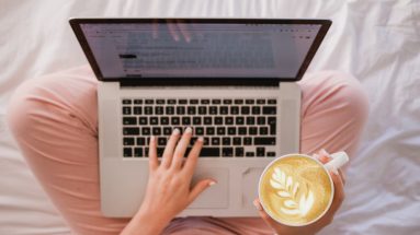 Woman enjoying cappuccino while on the MacBook Pro