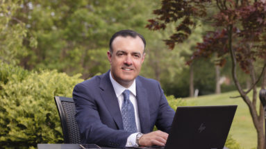 Business owner sitting outside with laptop computer.