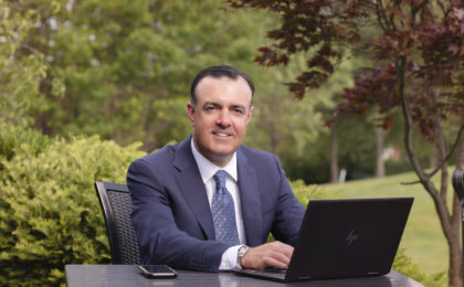 Business owner sitting outside with laptop computer.