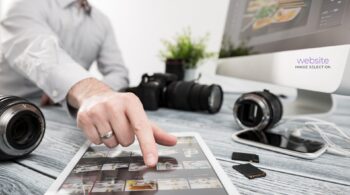 Photo of photographer helping client select images for their website.